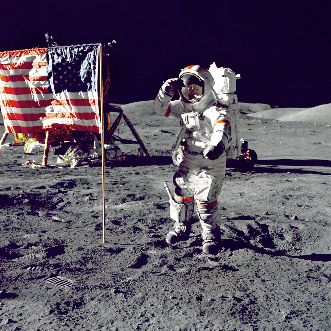 astronaut standing on the moon saluting an American flag